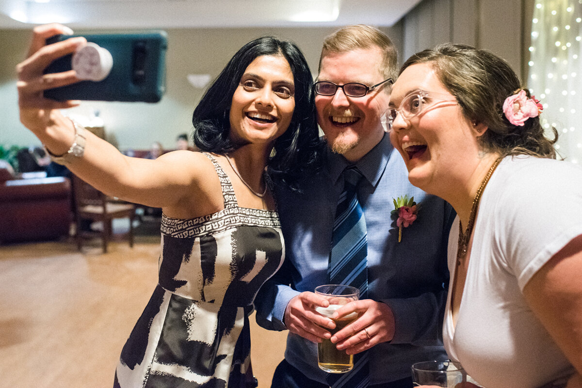 Bride, groom, and guest taking a selfie at Kingston, Ontario wedding