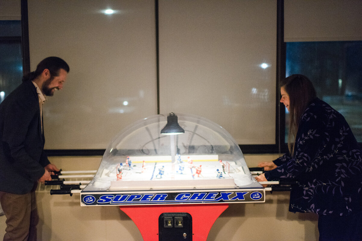 Guest and officiant playing foosball at Kingston, Ontario