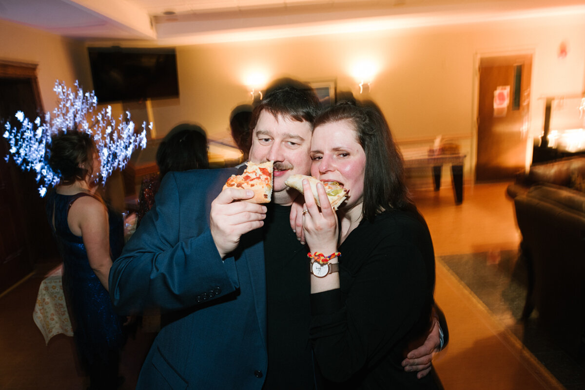 Guests eating midnight pizza at wedding reception