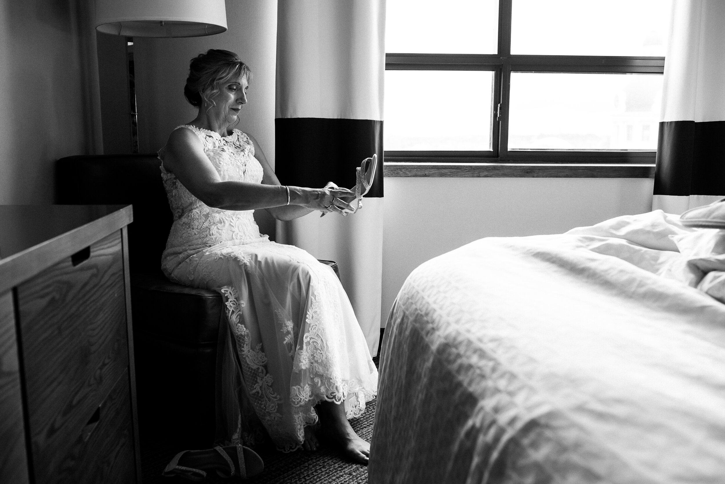 Bride putting her shoes on before wedding in Kingston, Ontario