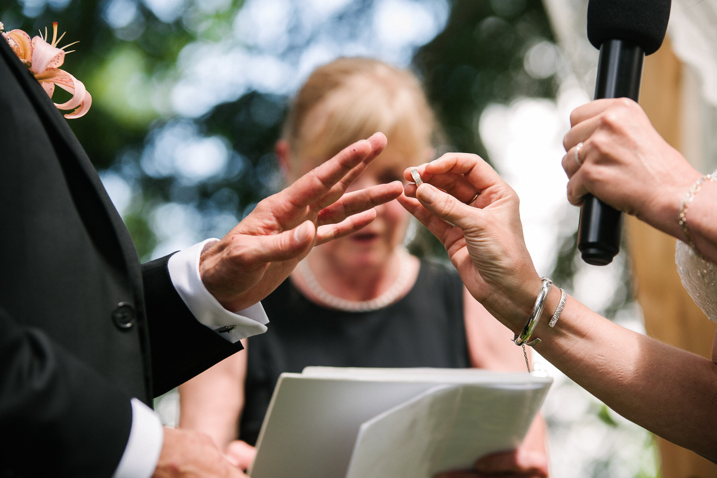 Bride putting ring on groom's finger during ceremony at Verona, Ontario wedding