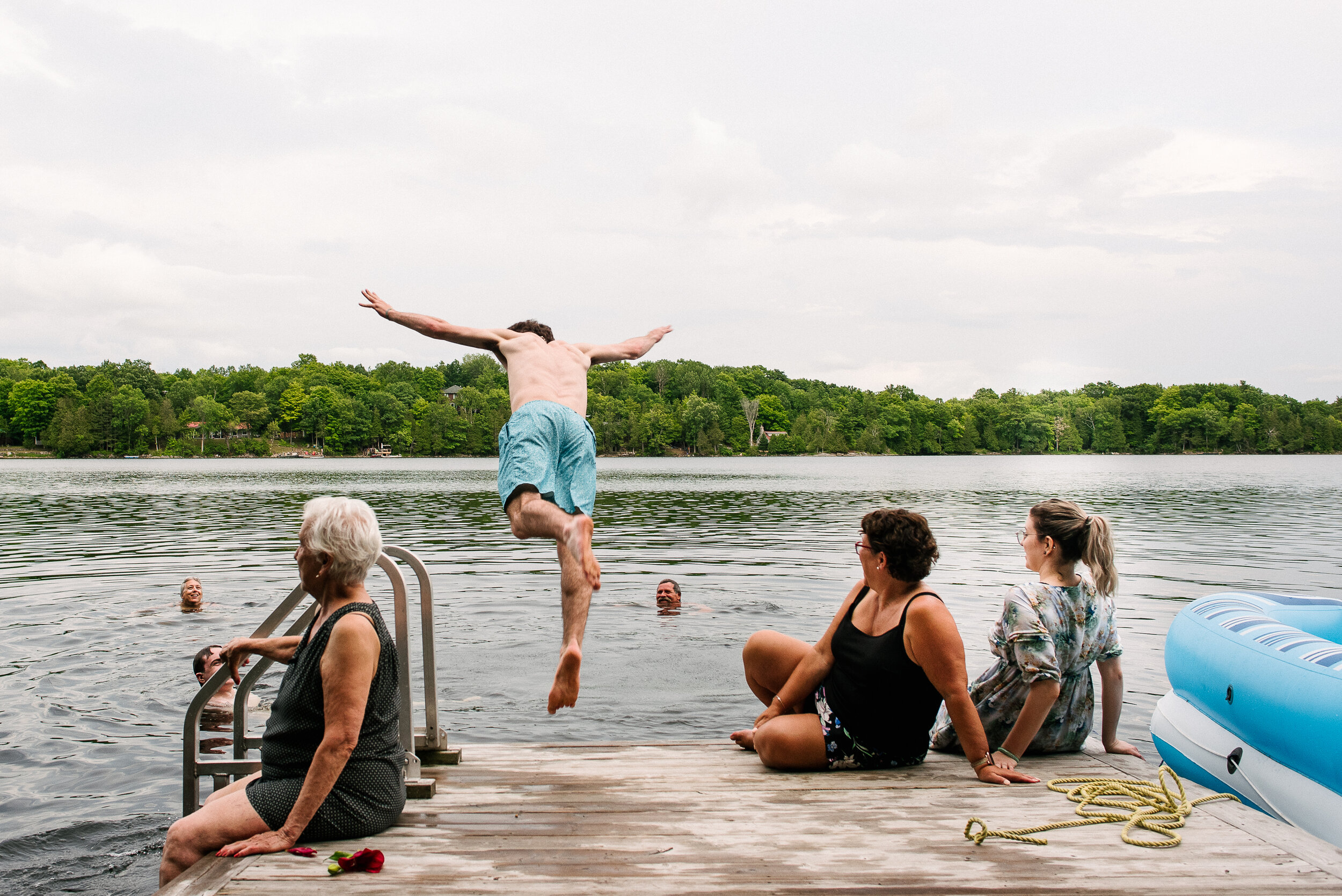 Guests jumping and swimming in the lake at Verona, Ontario wedding 