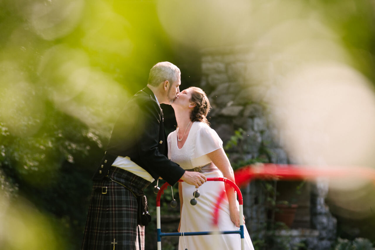 bride and groom kissing while playing lawn games