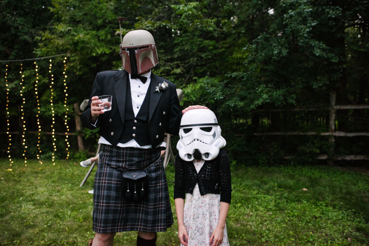 Groom and child wearing star wars cosplay helmets