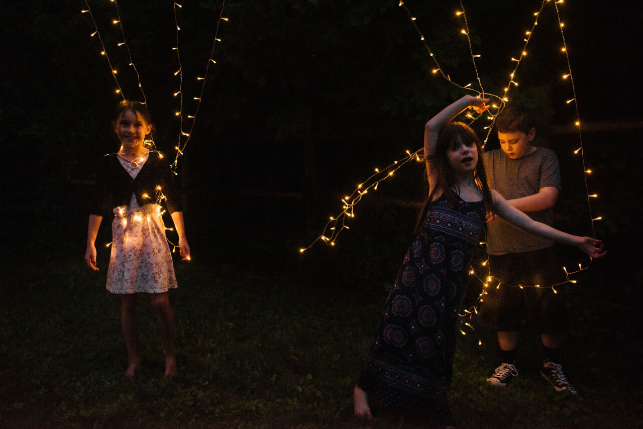Young guests play with string lights at Ottawa wedding 