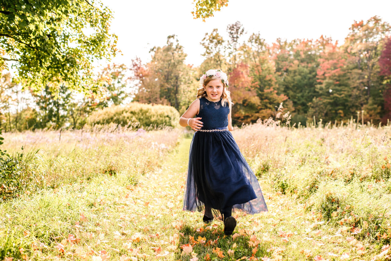 Flower girl running down pathway at rural Ontario elopement 
