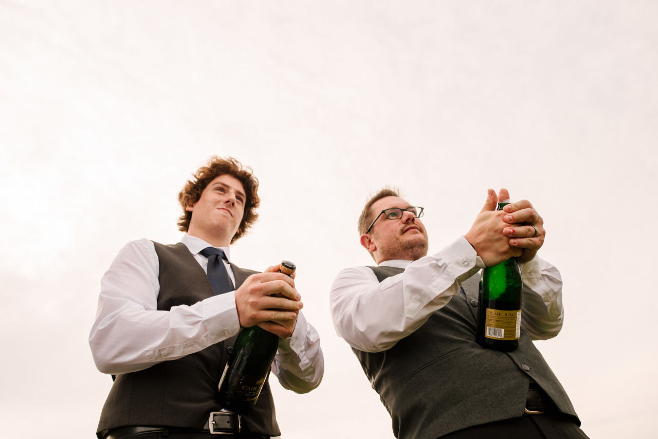 Groomsmen popping champagne at rural Ontario elopement 
