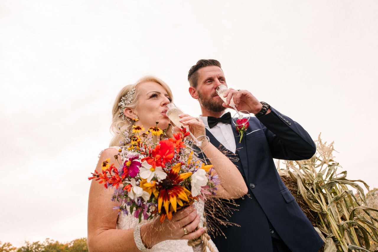 Bride and groom drinking champagne after their ceremony at rural Ontario elopement 