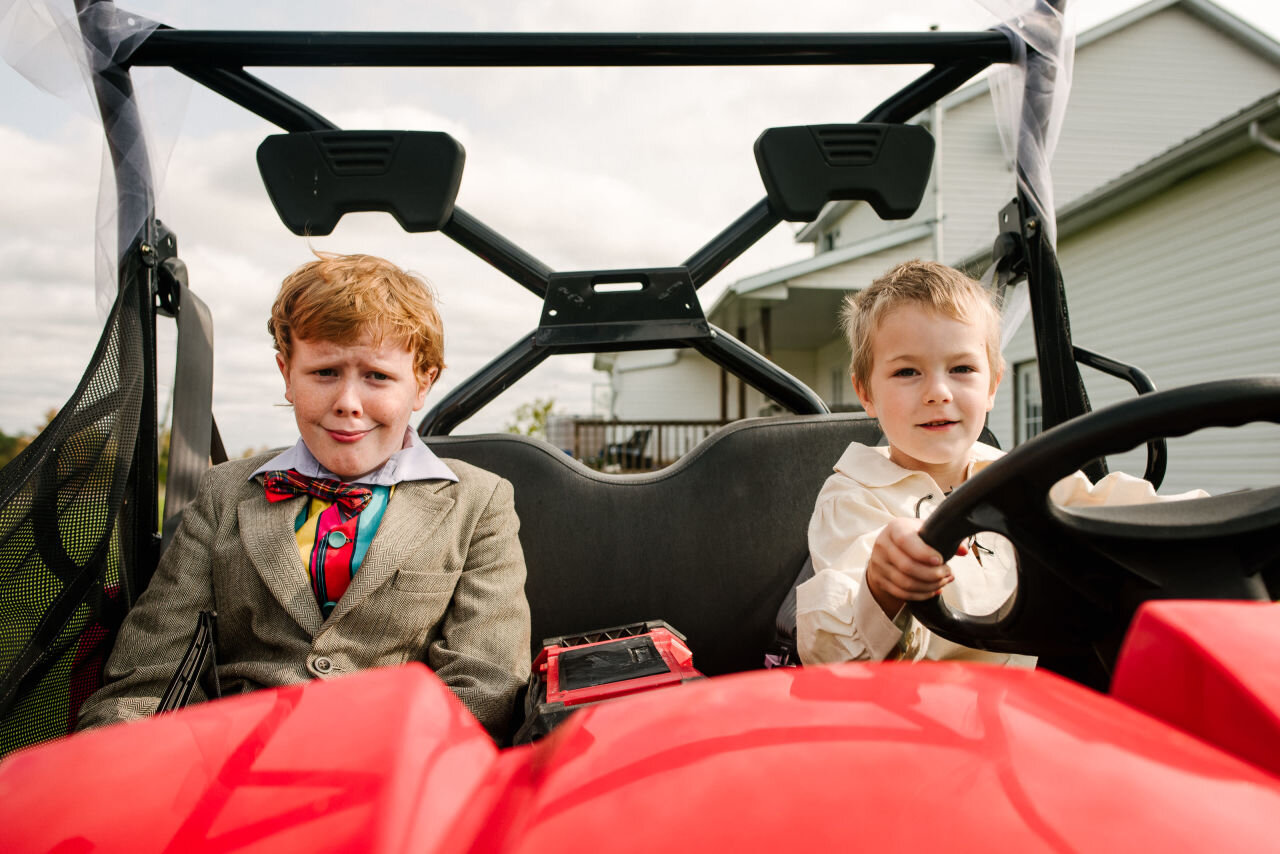 Young wedding guests driving a four wheeler at rural elopement near Kingston, Ontario