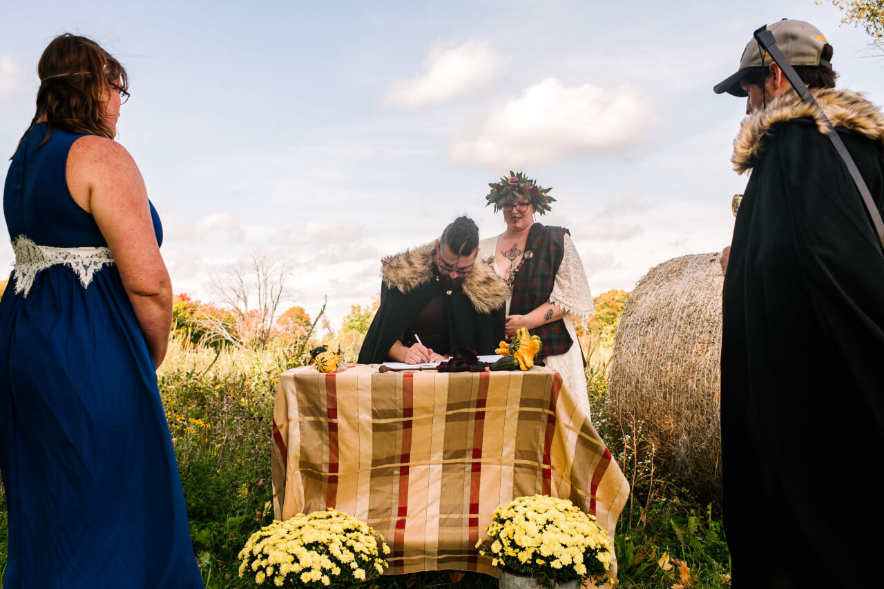 Bride signing the documents at rural elopement near Kingston, Ontario