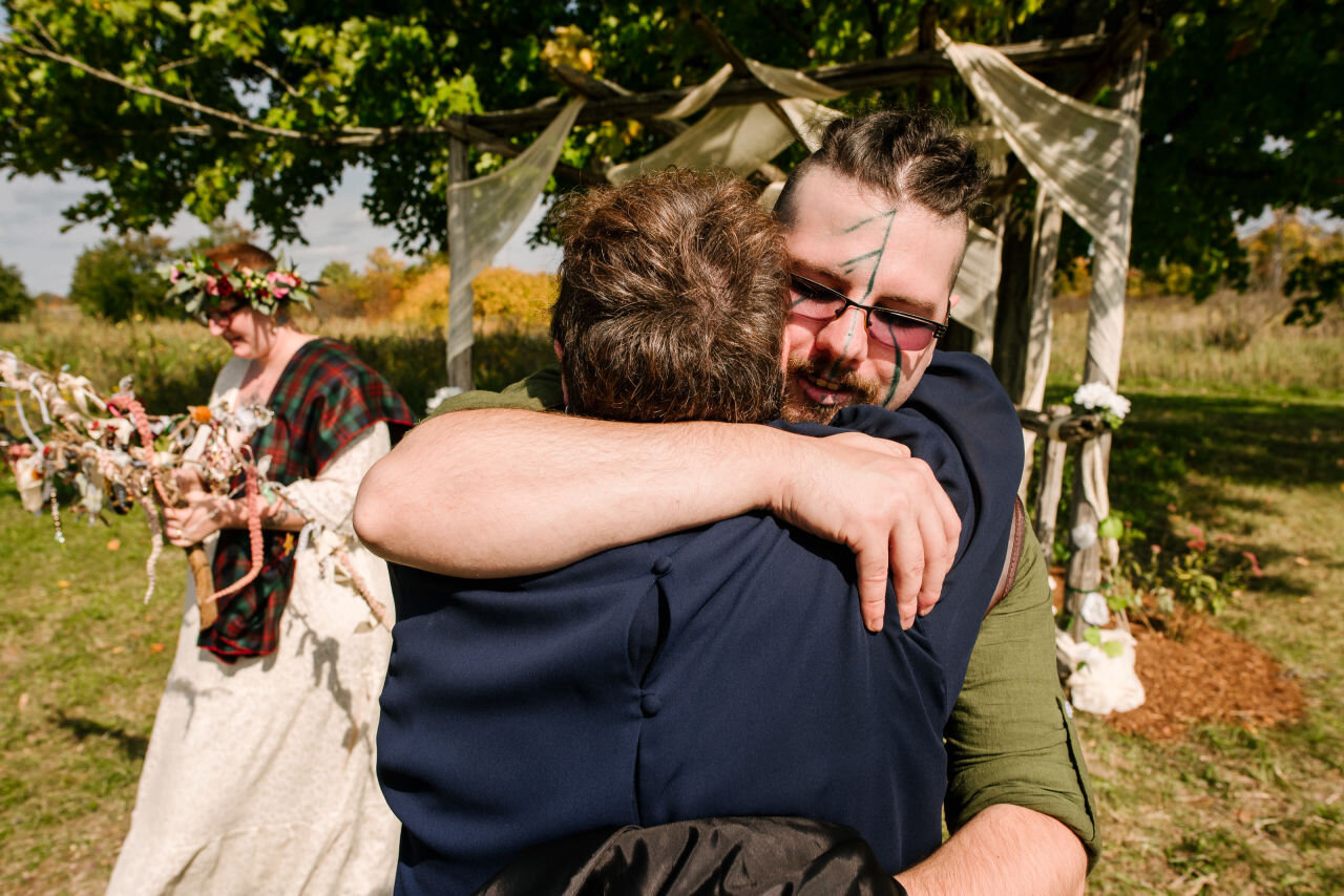 Groom hugging guest at rural elopement near Kingston, Ontario