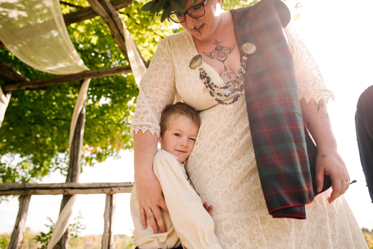 Bride with son in sunbeam at rural elopement near Kingston, Ontario