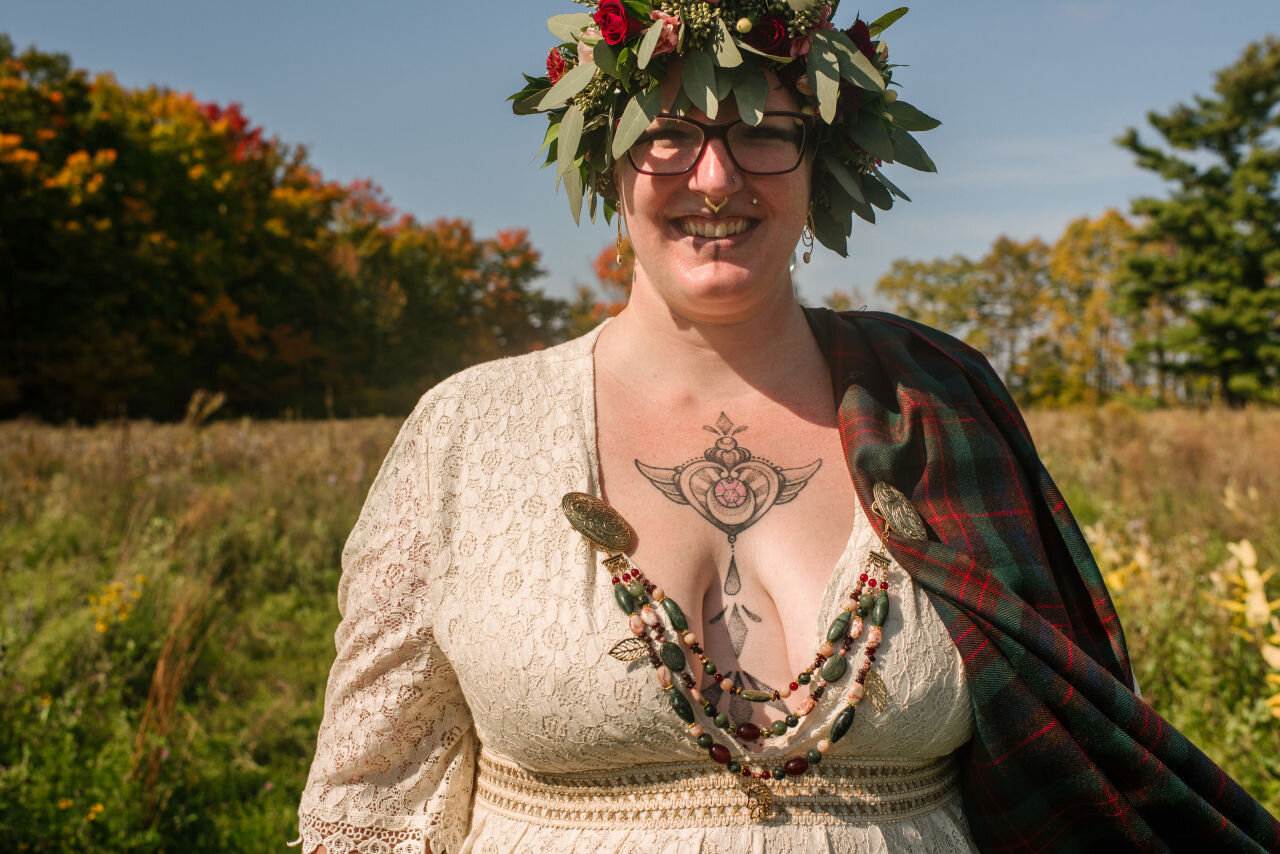 Bride posing for a shot displaying her tattoos at rural elopement near Kingston, Ontario