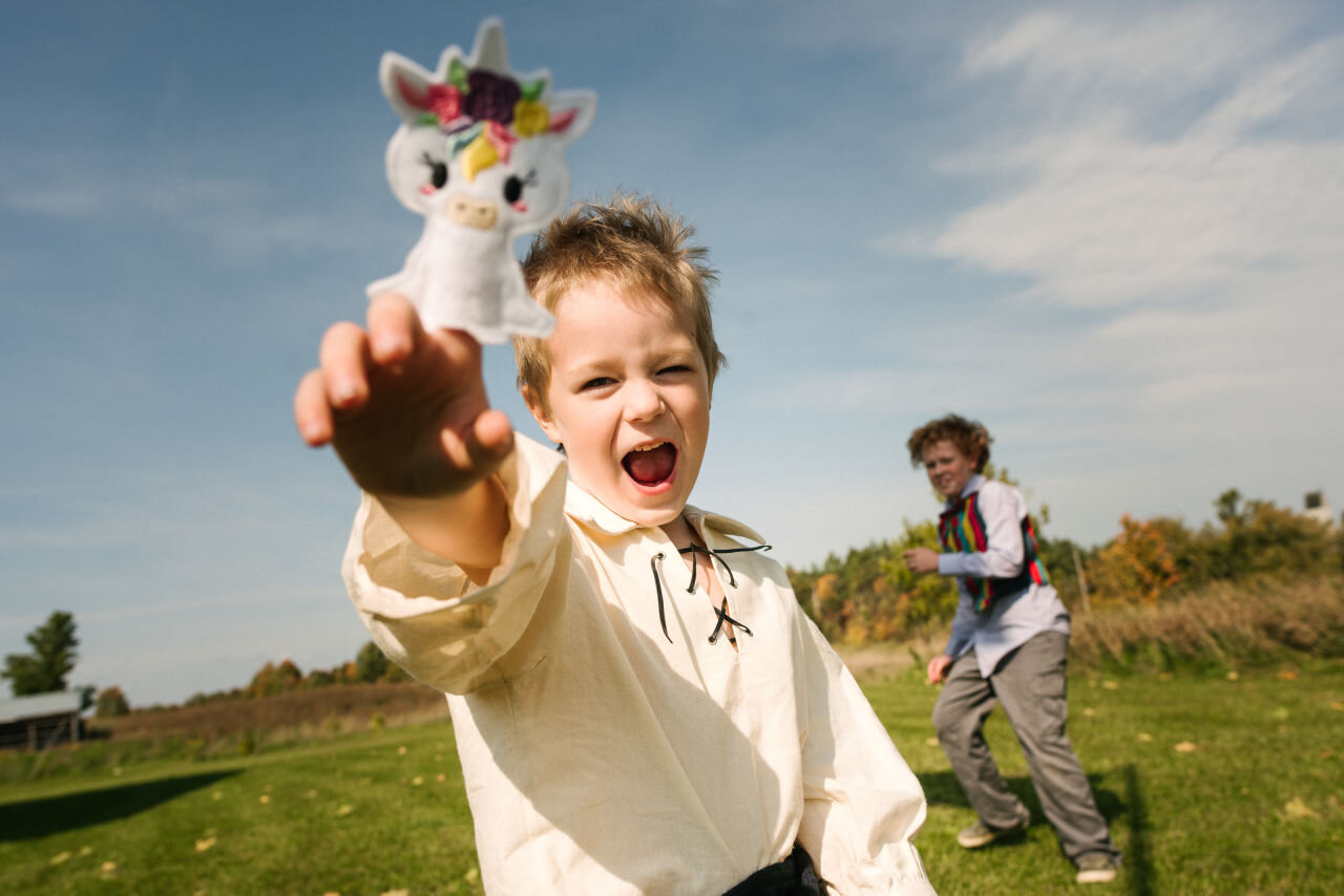 Young boy plays with a toy during rural elopement near Kingston, Ontario