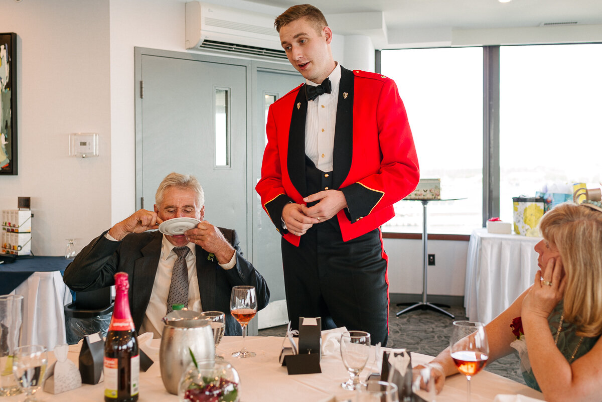 Groom wearing red uniform giving speech at wedding