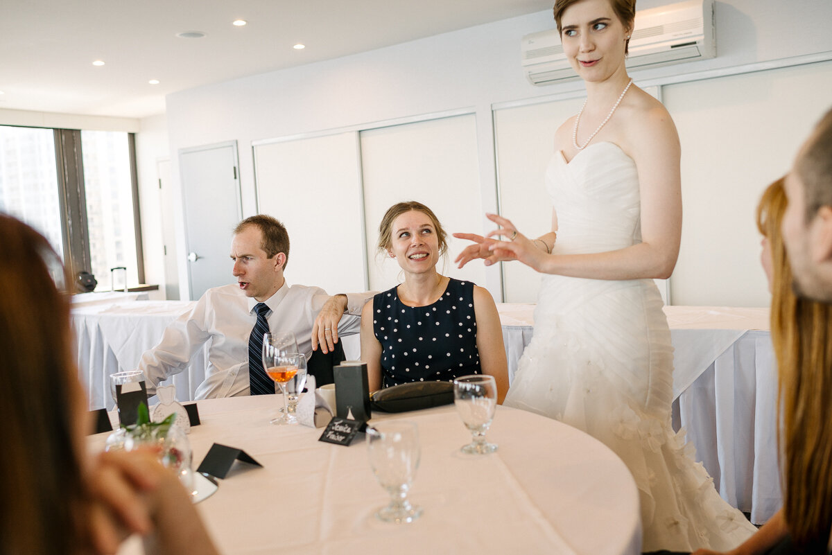 Bride making funny face while speaking with guests