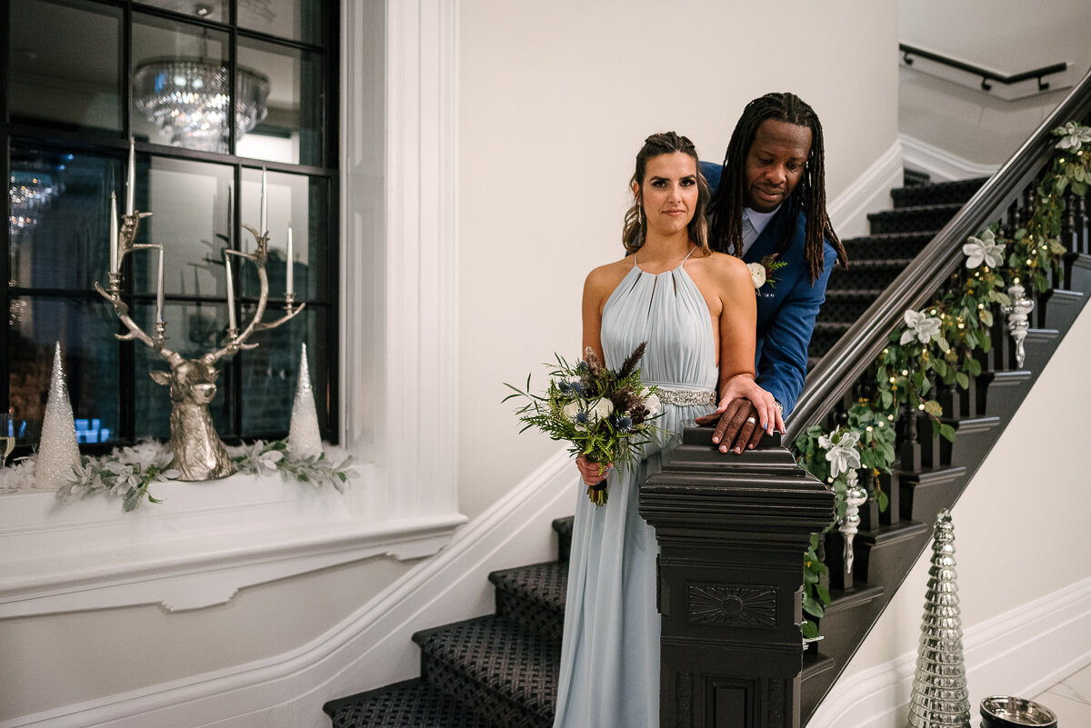 Bride and Groom pose in front stairway of the Frontenac Club 