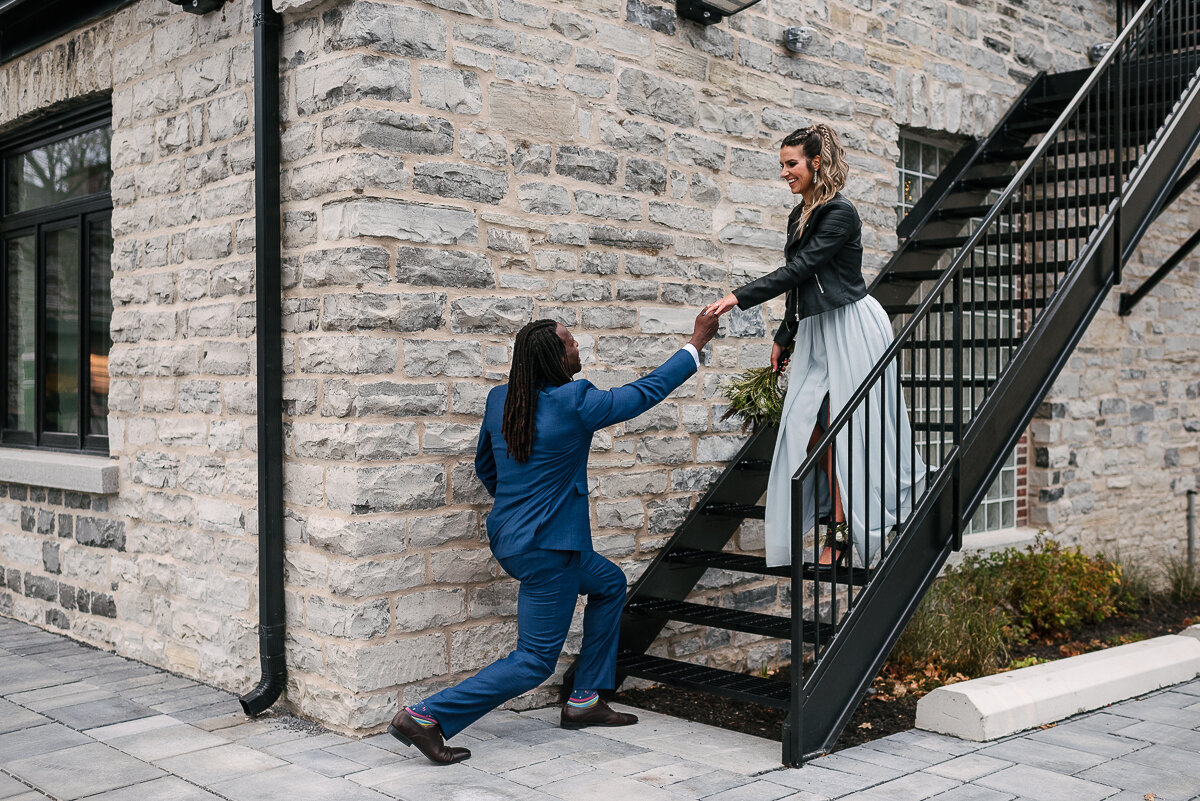 Groom helps bride down the stairs at the Frontenac Club 