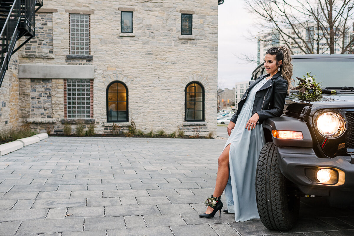 bride posing with black jeep in leather jacket 