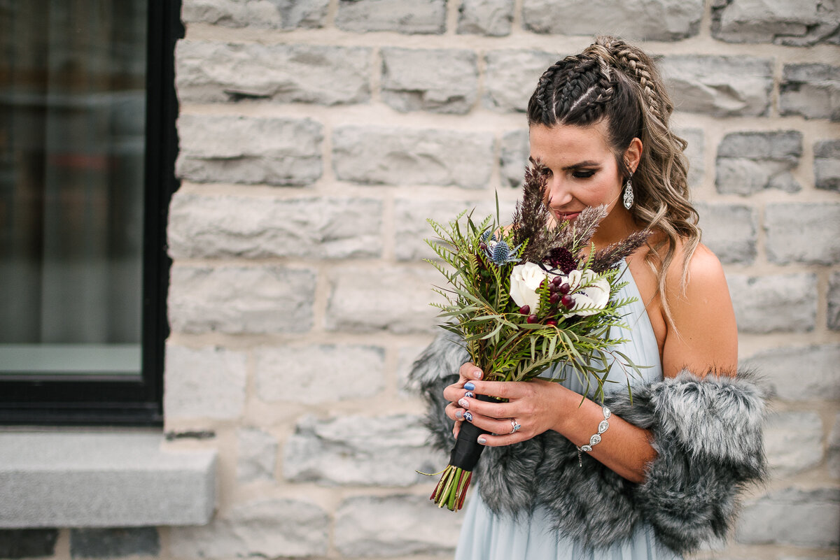 Bride smelling her bouquet by Kingston Flower Market 