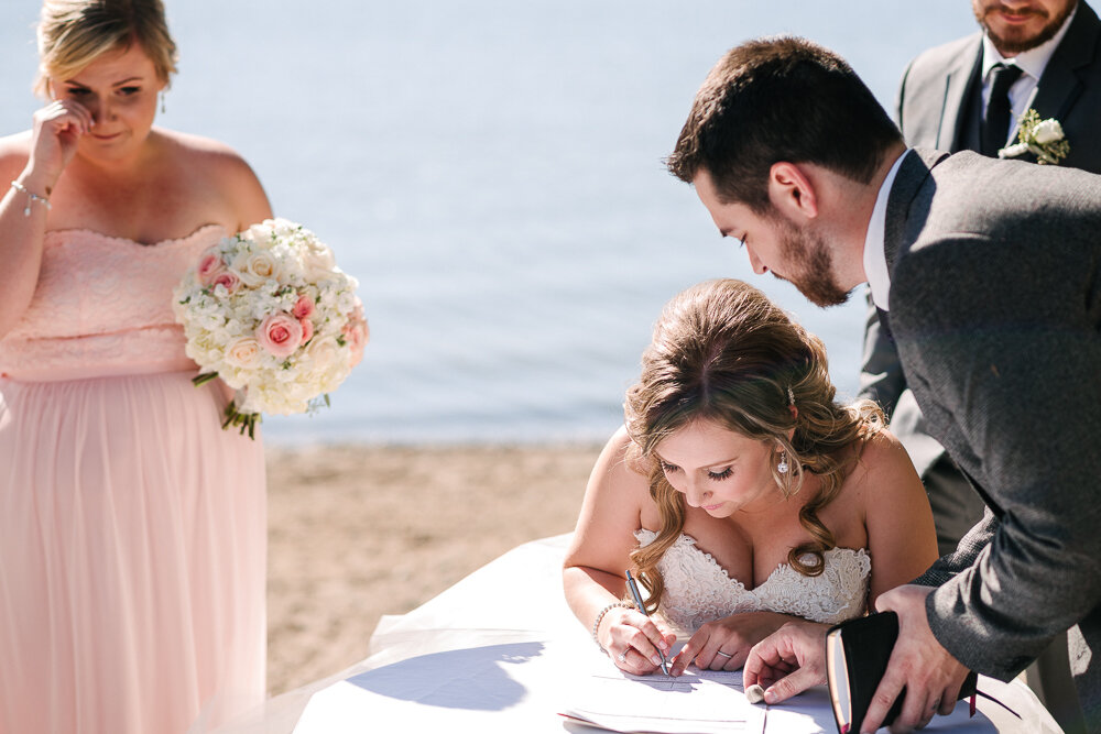 close up of bride signing the papers after ceremony 