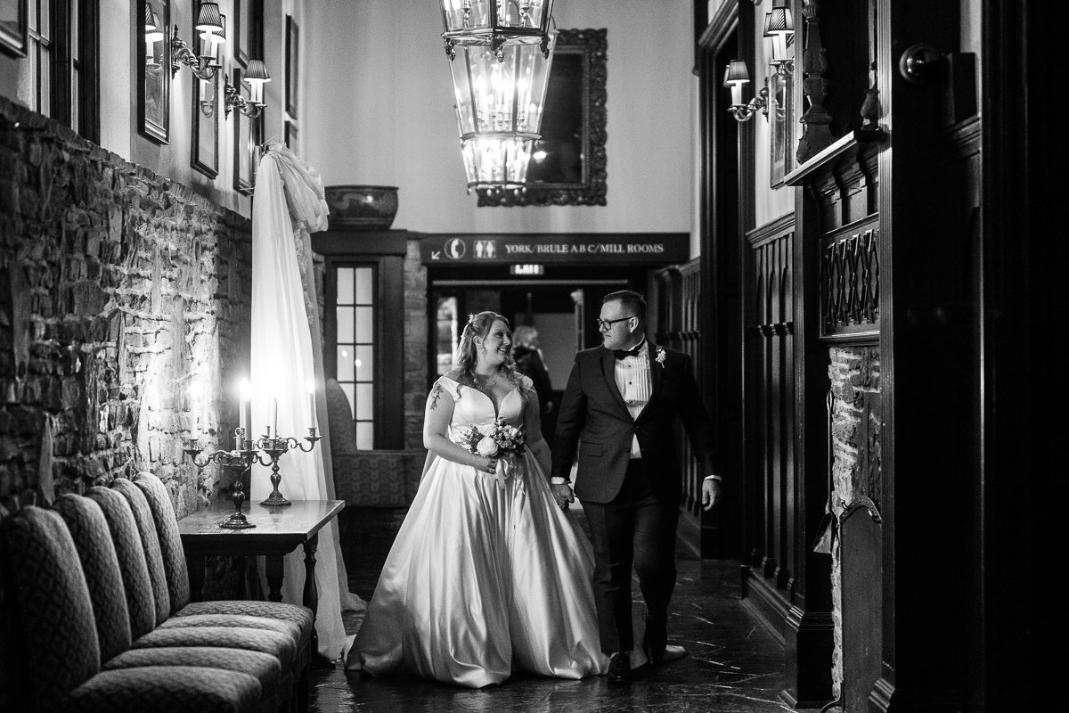 Black and white image of bride and groom walking down the aisle