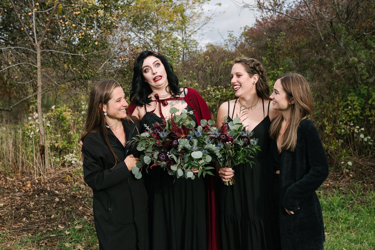 Bride with bridesmaid in black outfit.