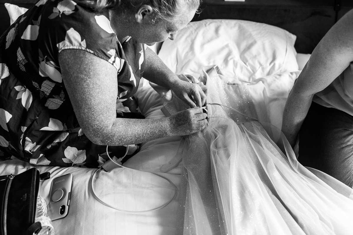 Black and white picture of brides wedding gown getting ready