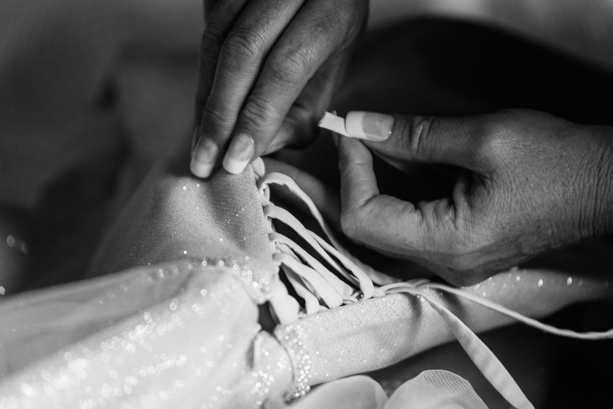Black and white image of wedding gown getting ready for the bride