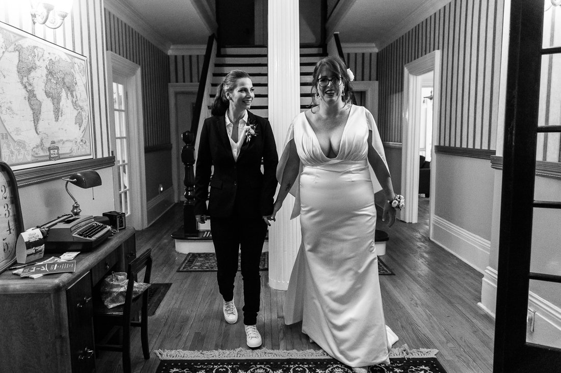 Black and white picture of Brides walking hand in hand 