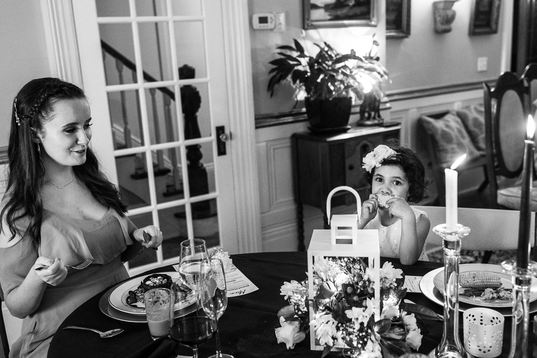 Black and white picture of guests having dinner at the wedding reception. 
