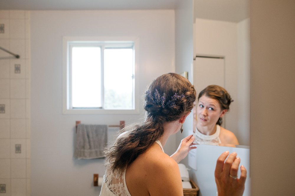 Bride looking into the mirror after getting ready.