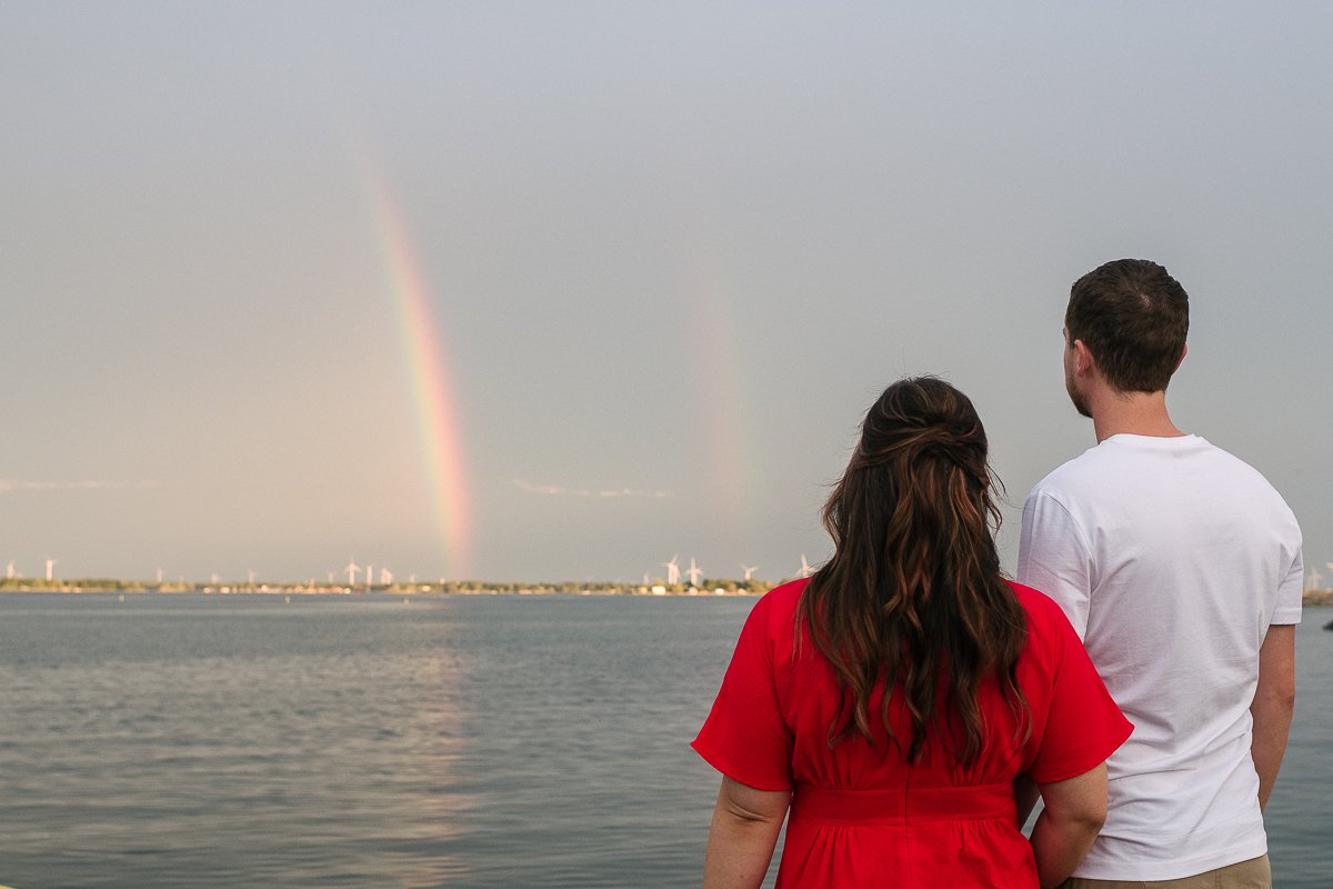 Couple looking at the rainbow on their engagement day