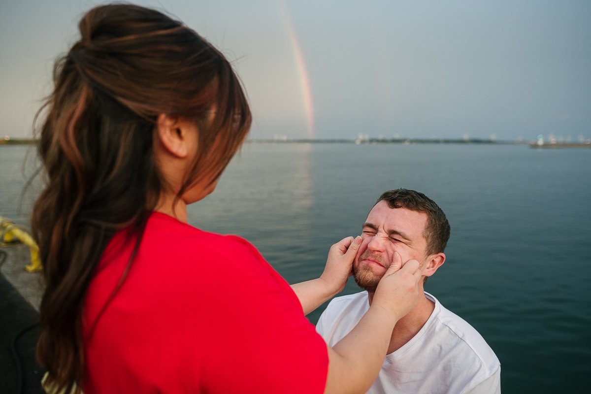 Woman squeezing her man's cheek.