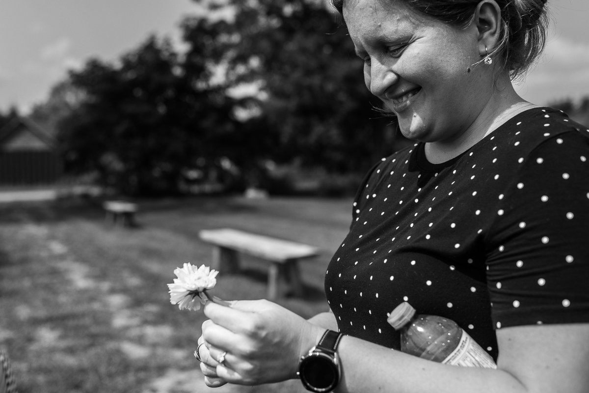 Black and white picture of woman collecting flowers in the garden.