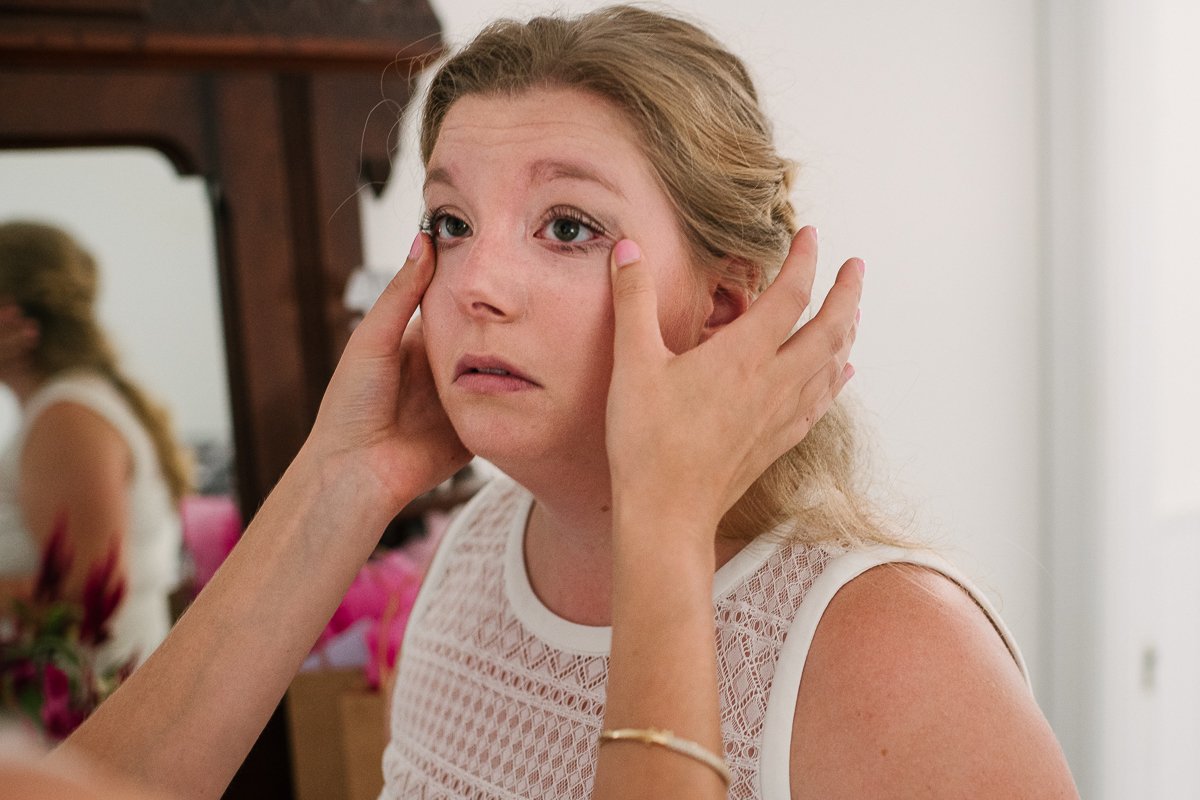 Brides sister doing makeup on the wedding day