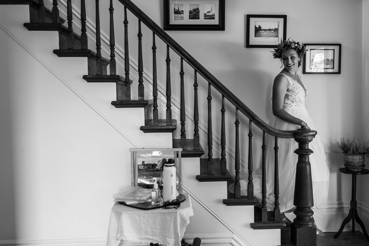 Black and white picture of the bride walking down the stairs