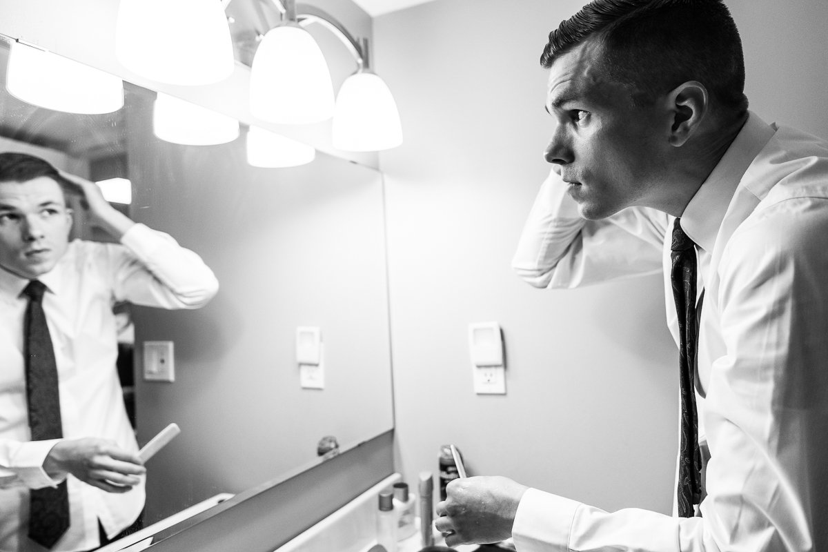 Black and white image of groom getting ready. 