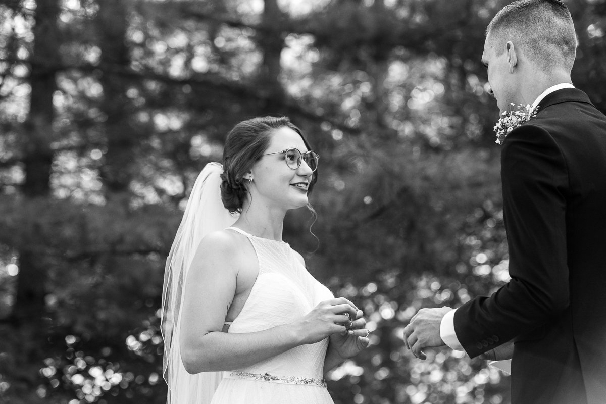 Black and white image of Bride and groom exchanging rings