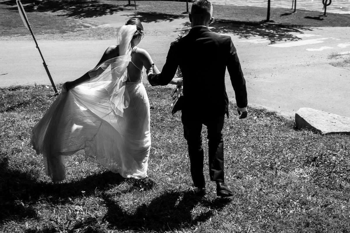 Black and white image of Bride and groom walking after their wedding. 