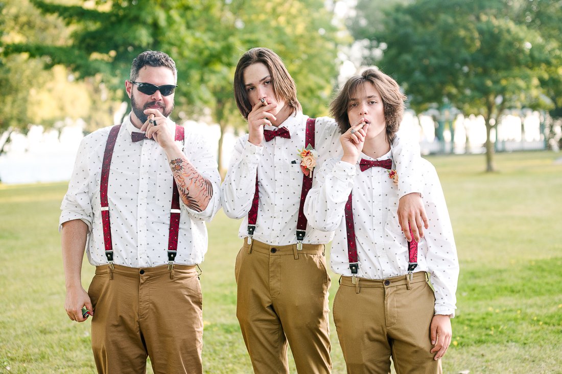 Father and sons smoking cigar during wedding function