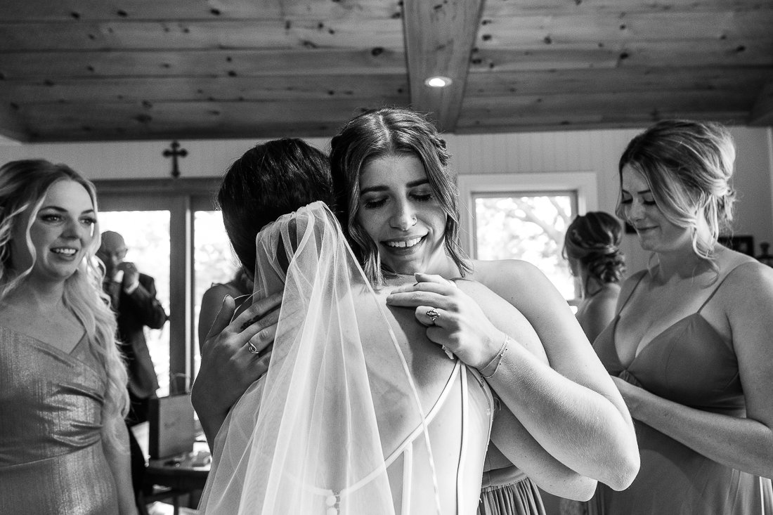 Black and white image of bride meeting her bridesmaid. 