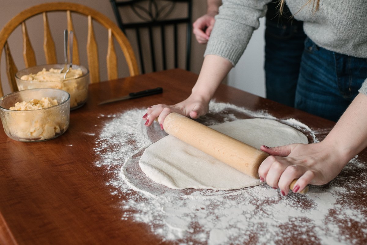 Woman rolling dough to make perogies on her engagement.