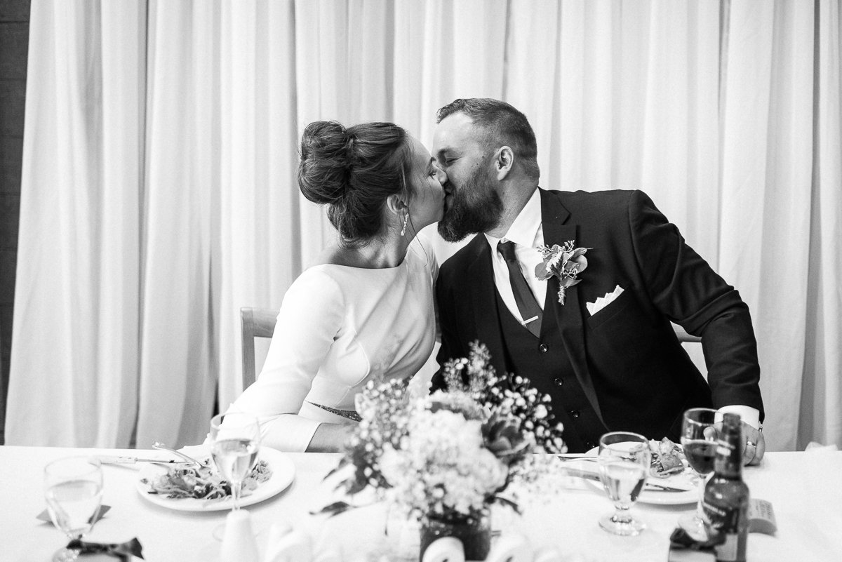 Bride and groom kissing during the dinner party
