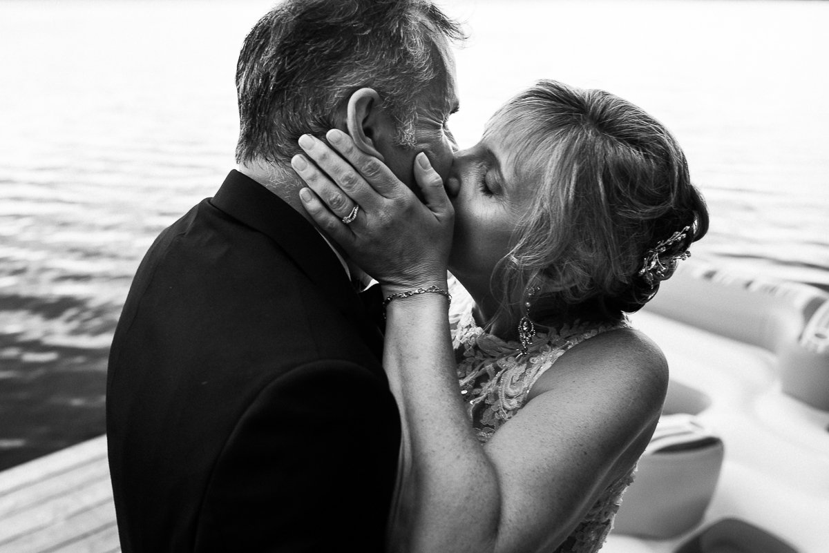 Bride and groom kissing on the water boat