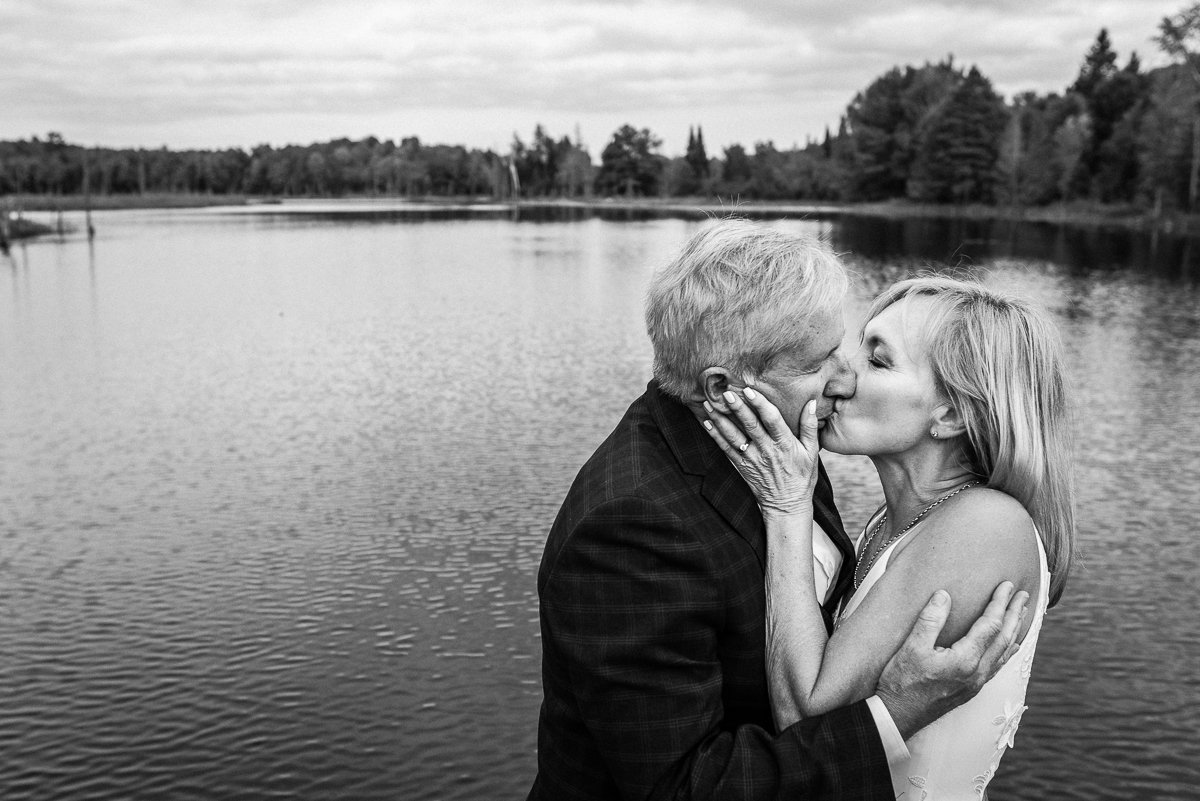 Bride and groom kissing near lake