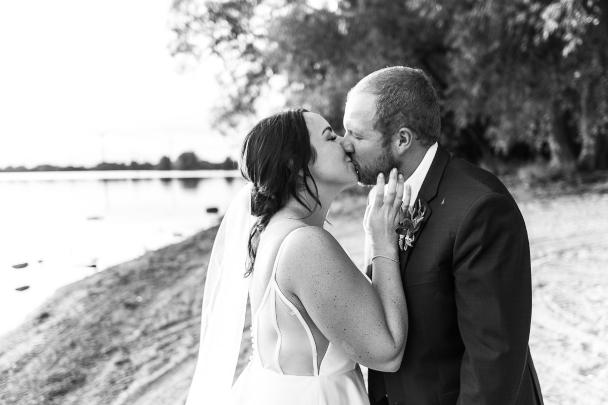 Bride and groom kissing near the lake