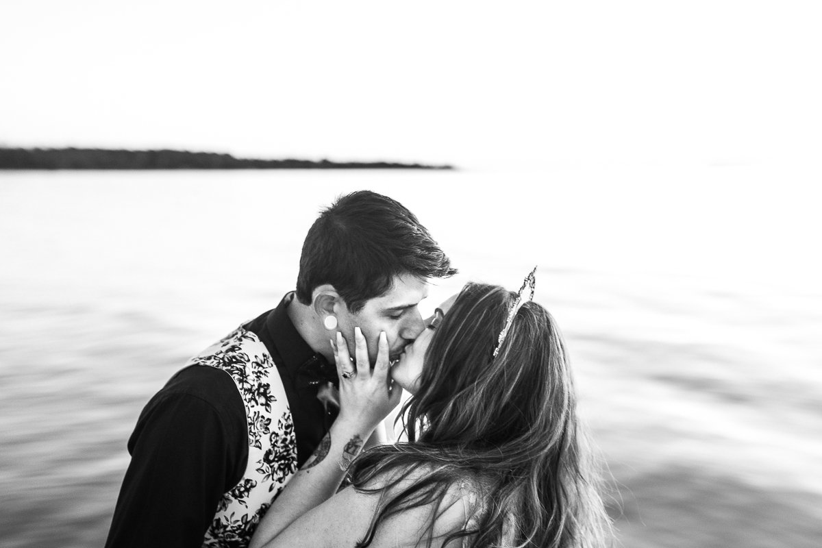 Bride and groom kissing near the sea.