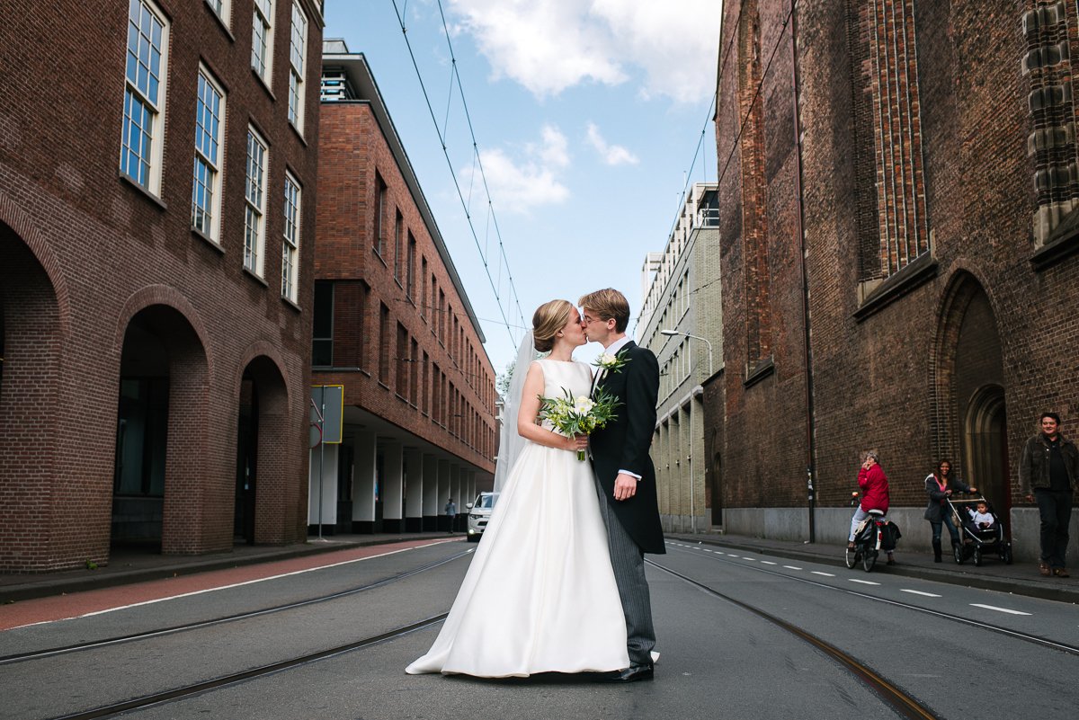 Bride and groom kissing on the street