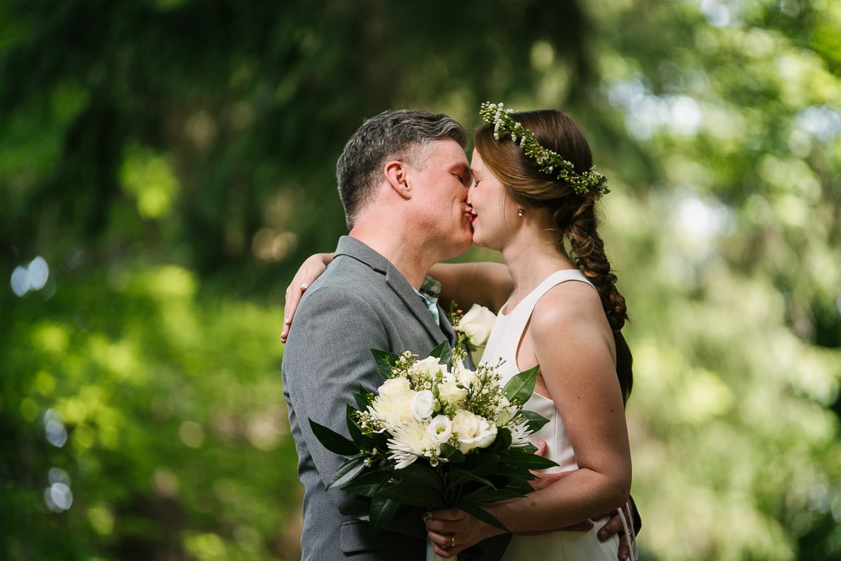 Bride and groom kissing holding the flower bouquet
